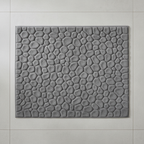 Vue de dessus du tapis de bain gris à motif galets sur carrelage gris