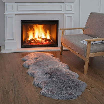Tapis fausse fourrure gris devant une cheminée allumée dans un salon cosy
