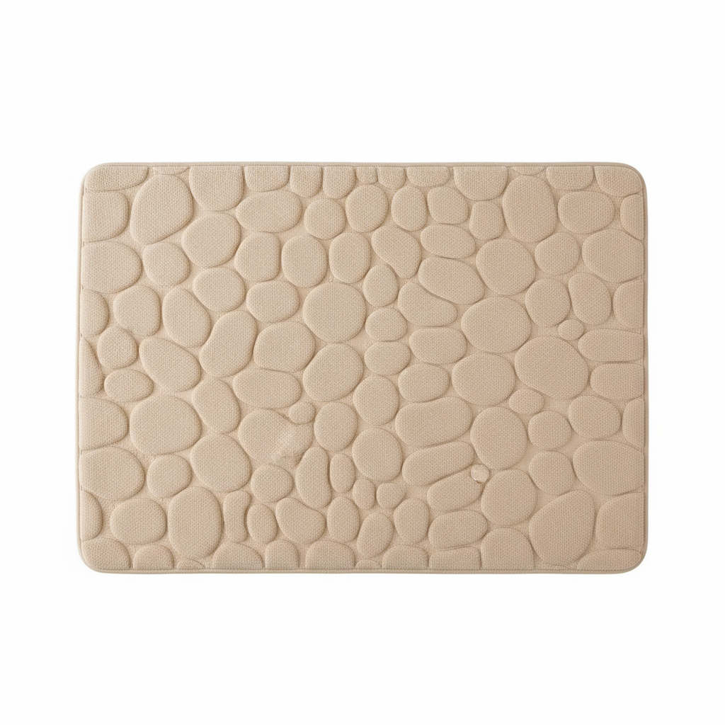 Gros plan sur la texture galets du tapis de bain beige fond blanc