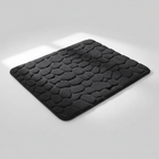 Tapis de bain noir galets sur fond gris clair avec ombre élégante