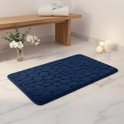 Tapis de bain bleu marine dans une ambiance spa réaliste avec marbre blanc et orchidées