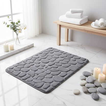 Tapis de bain gris dans une ambiance spa lumineuse avec marbre blanc et orchidées